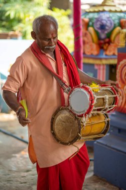 Man using Dholak drums in a temple at Nellore, Andhra pradesh, India, 01 Aug 2022