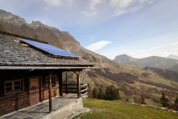 Ecological chalet with solar panels on the roof in the French Alps. Sustainable development and green energy