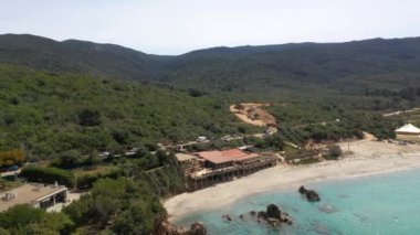 Drone flying over tropical blue water in Corsica. Aerial view of a sand beach with deep blue water in France in summer.