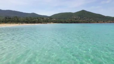 Korsika 'da tropikal mavi suyun üzerinde uçan insansız hava aracı. Fransa 'da yazın koyu mavi suyu olan kumsal manzarası..