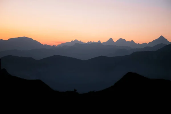 First sunlight on the mountains of the Lac de Peyre in French Alps. Mountain layers at blue hour at sunrise