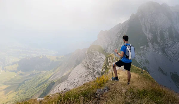 Solo hiker admiring the view on top of a mountain. French Alps view of the Col des Aravis - tourism and vacation - Pointe de Merdassier