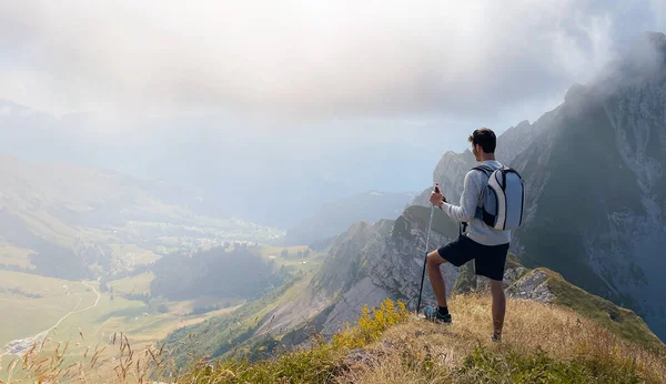 Solo hiker admiring the view on top of a mountain. French Alps view of the Col des Aravis - tourism and vacation - Pointe de Merdassier
