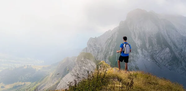 Solo hiker admiring the view on top of a mountain. French Alps view of the Col des Aravis - tourism and vacation - Pointe de Merdassier