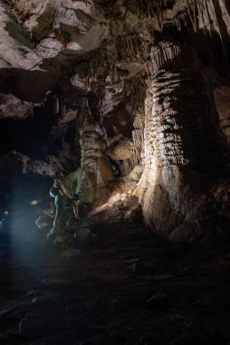 cavers inspect the cave with a light bulb looking for stalactites and stalagmites