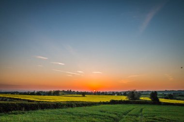 Kuzey Yorkshire, İngiltere 'deki tarlaların yanındaki parlak gün batımı