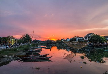 Nehrin üzerinde gün batımı ve Hoi An, Vietnam 'da tekneler.
