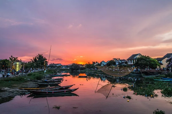 Nehrin üzerinde gün batımı ve Hoi An, Vietnam 'da tekneler.