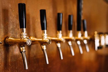 Bir sıra barın iç tarafındaki bakır duvarda biralardan çok var.