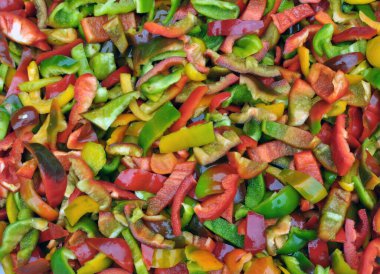 Çok renkli sebze arka planında doğranmış dolma biber var.