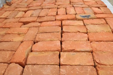 Yığının içinde balçıktan yapılmış hazır bir tuğla var.