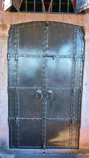 Kilitli paslı metal bir kapı.