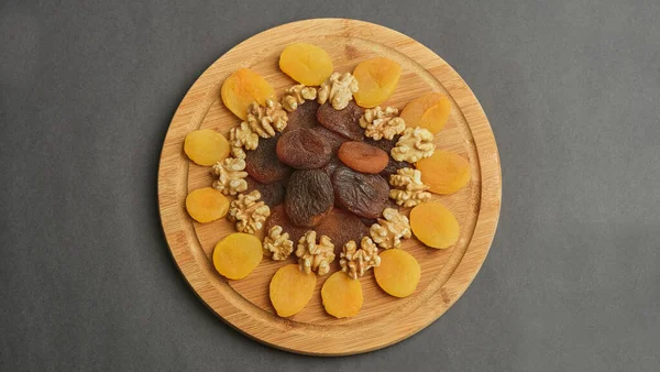 top view of a bowl of fruits and nuts on a black background