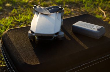 Malang, Indonesia -  August 20th 2022:  DJI Mini 2 and battery on a hard case bag on a grass background, selective depth of field