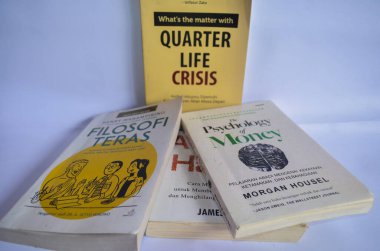 BLITAR, INDONESIA - 9 Ekim 2022: Çeyrek Yaşam Krizi, Teras Felsefesi ve Paranın Psikolojisi başlıklı çok sayıda kitabın bulanık etkisi