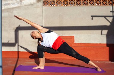 Young women practicing yoga on a sunny day
