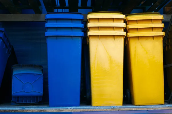 Paper and plastic recycle bins, yellow and blue