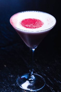 Koyu arkaplanda kokteyl ile martini bardağı