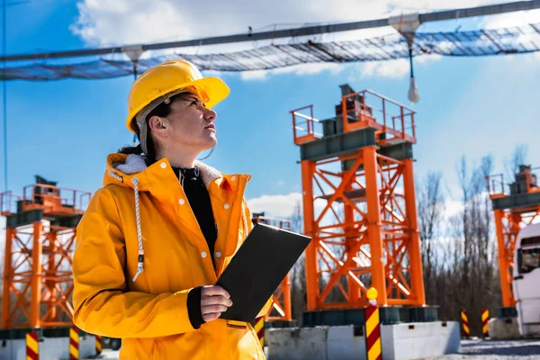 Women engineer with digital tablet on the construction site under the blue sky