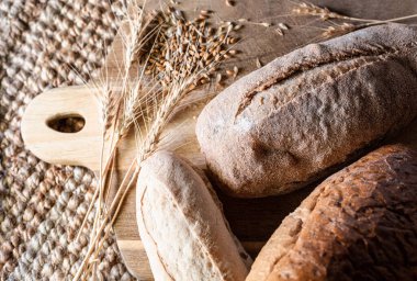Breads variety on wood table and raw cereals from above