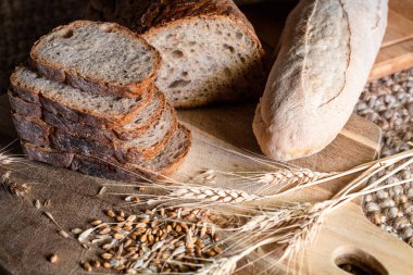 Rustic breads variety with raw wheat seeds on wood table