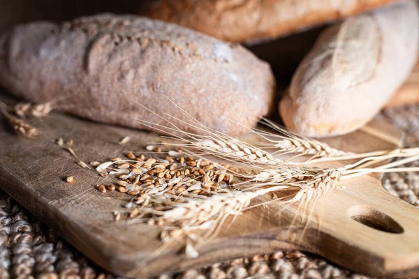 Rustic baked bread close up with wheat seeds on wood table