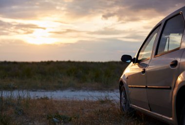 Parked car in nature during the sunset