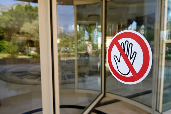 Social distancing sign attached to the revolving door in hotel informing people to keep distance, prevent spreading  COVID-19 virus