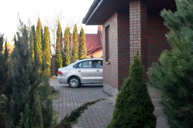 Arka bahçedeki garajın yakınına park edilmiş arabanın arka kısmı. Seçici odak.