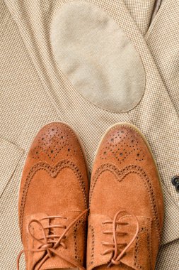 Açık bej ceketli, kahverengi süet spor ayakkabılı erkekler. Üst görünüm.