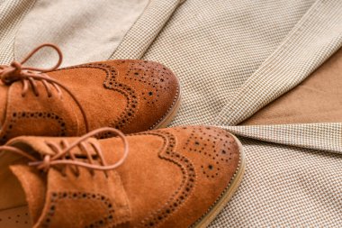 Erkekler kahverengi süet derbi ayakkabıları ve açık bej ceket. Seçici odak.