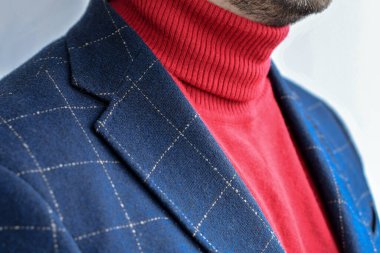 Koyu mavi yün ceket ve şık kırmızı kazak. Seçici odak.