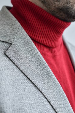 Açık renk tüvit ceketle parlak kırmızı kazak giyen adamlara yakın durun. Seçici odak.