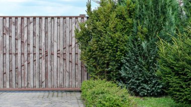 Fragment of grunge wooden entrance gate to the mansion with a pavement. Copy space. 