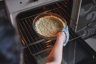 Kadın elleri fırına kek koymak için pasta koyuyor. Düşük Dof. Üst görünüm