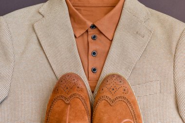 Kahverengi süet ayakkabılar ve açık bej gömlek. Yaz manzarası. Seçici odak.