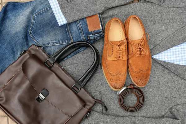 一双棕色的绒面革皮鞋 蓝色牛仔裤 皮革和灰色斜纹皮夹克包带 随意的商业前景 顶部视图 — 图库照片