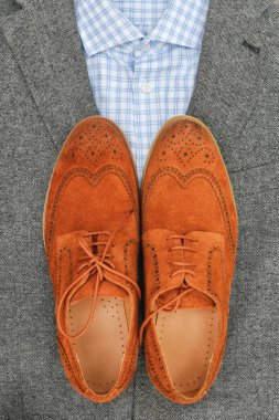 Gri tüvit ceketli bir çift kahverengi süet derbi ayakkabısı. Sıradan bir iş görüşü. Üst görünüm.