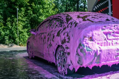 Car is covered with pink foam at self-service car wash