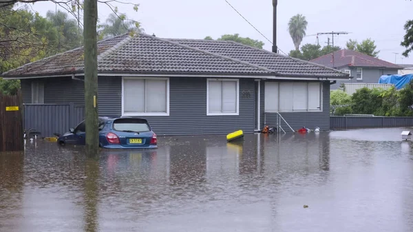 WINDSOR, AUSTRALIA - MAR, 23, 2021: widok z przodu samochodu i domu w Windsor pod wodą powodziową — Zdjęcie stockowe