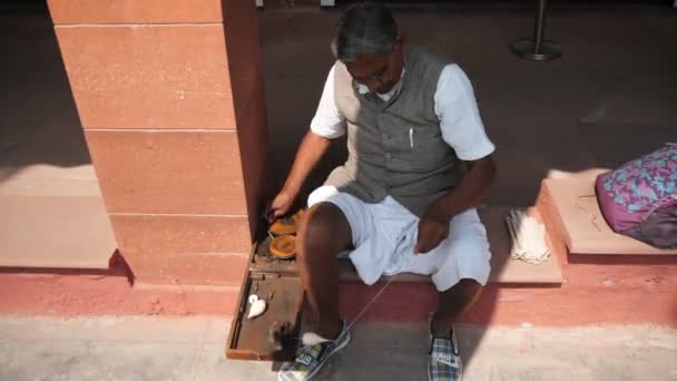 DELHI, INDIA - MARCH 15, 2019: людина, що пряде нитку зі складною прядкою, яку використовує ганді -4K 60p — стокове відео