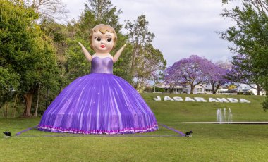 GRAFTON, AUSTRALIA - NOV 2 2021: NSW, Avustralya 'nın kuzey nehirleri bölgesinde grafton' daki jacaranda festivali sırasında parktaki güneşli dev bebek