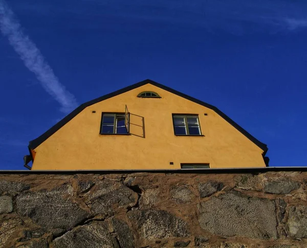 石垣の後ろの黄色の建物の低角度ビュー — ストック写真