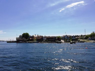 Bir ada üzerinde küçük bir kasabayla deniz manzarası 