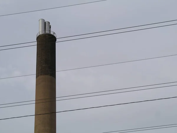 Низкий Угол Электрических Кабелей Перед Промышленным Дымоходом — стоковое фото