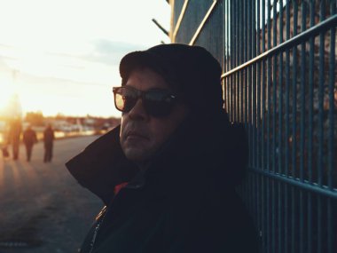 Gün batımında güneş gözlüğü takan adam