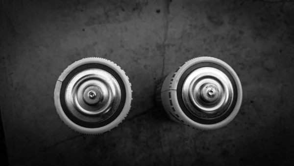 black metallic battery on a dark background. top view