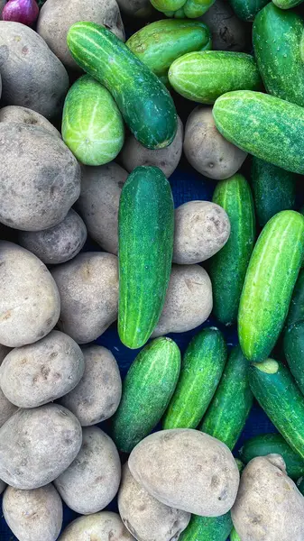 fresh ripe cucumbers and potatoes on the market