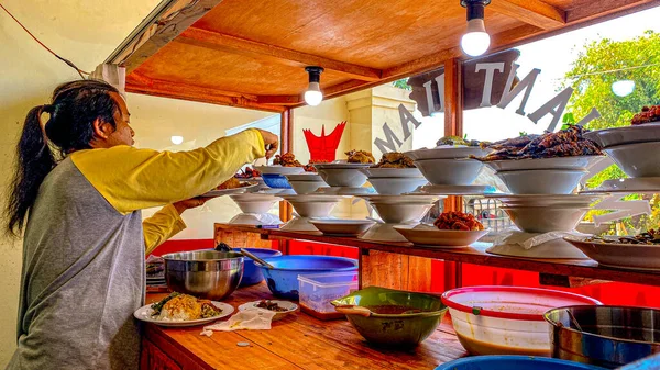 a cuisine photo of a padang restaurant and man taking food