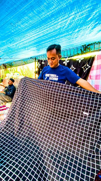young african man in a blue dress with his bed sheets